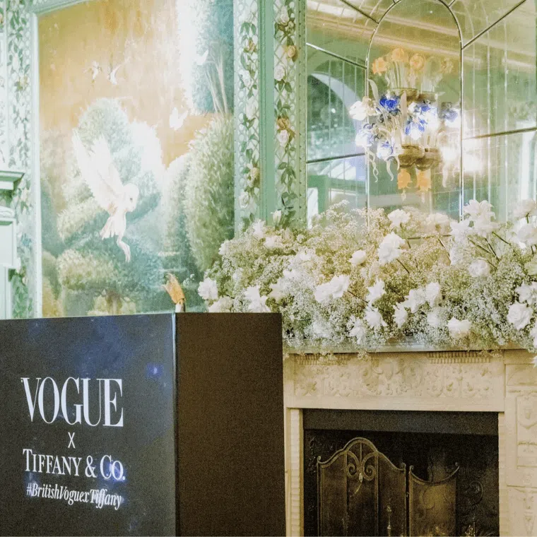 Fireplace decorated with white roses and baby's breath underneath a mirror