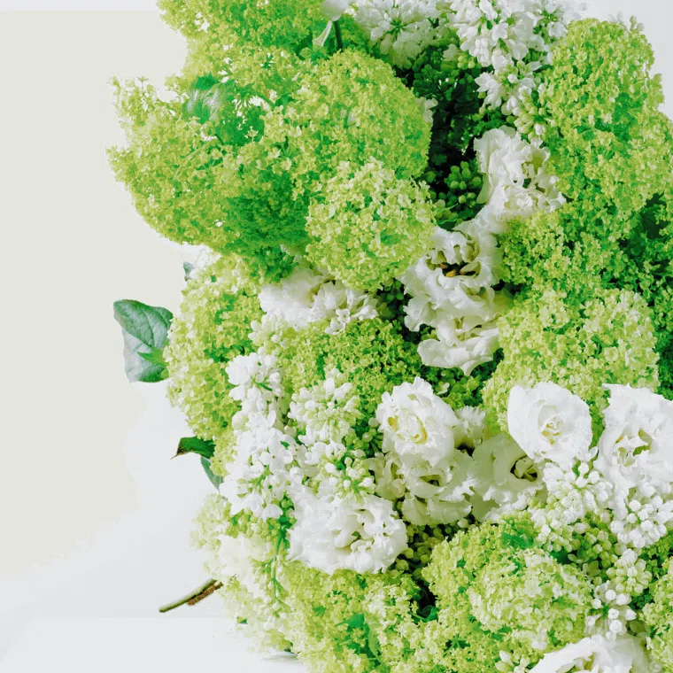 Green and white bouquet with viburnum, lisianthus, and lilac.