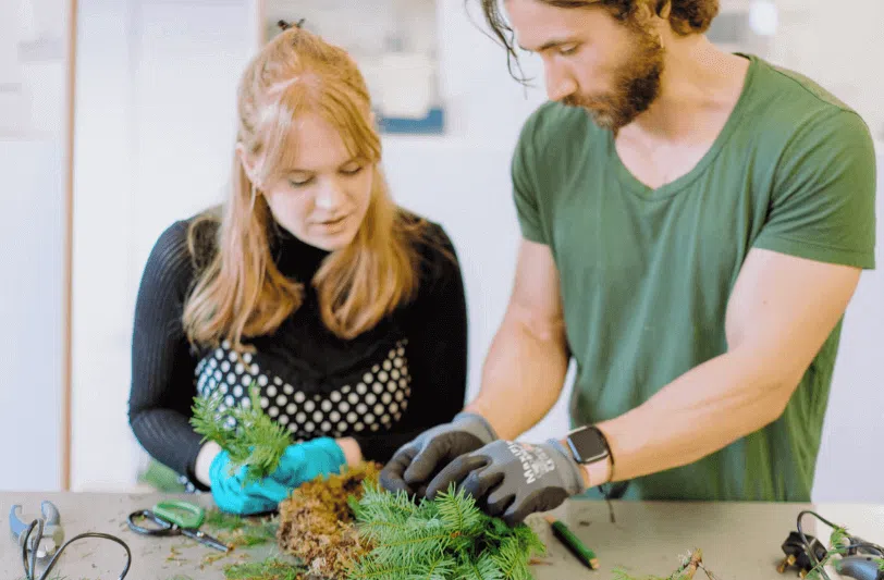 A man and a woman using foliage in floral design