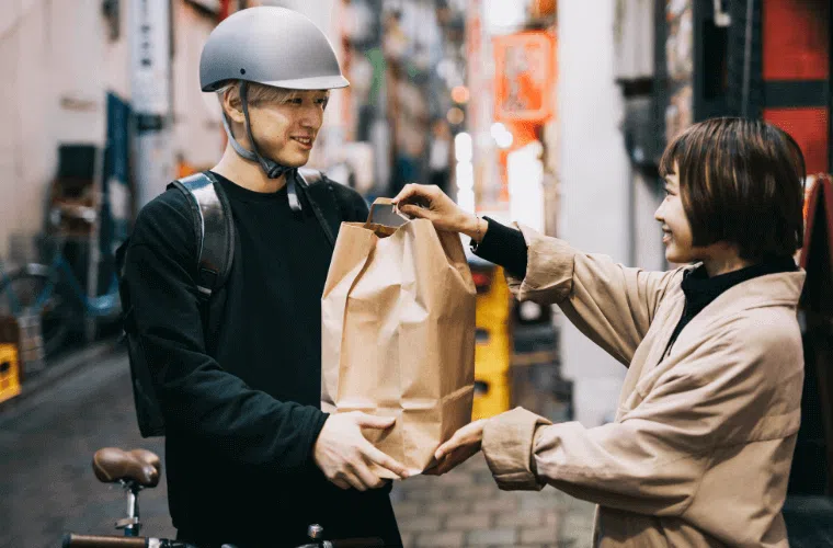 How can my business help fight climate change in 2025? 18 A male bicycle courier handing over a package to a woman