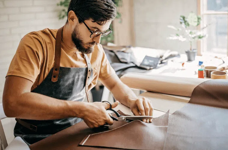 How can my business help fight climate change in 2025? 17 A man sat cutting material