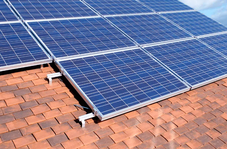 How can my business help fight climate change in 2025? 2 Solar panels on a tiled roof