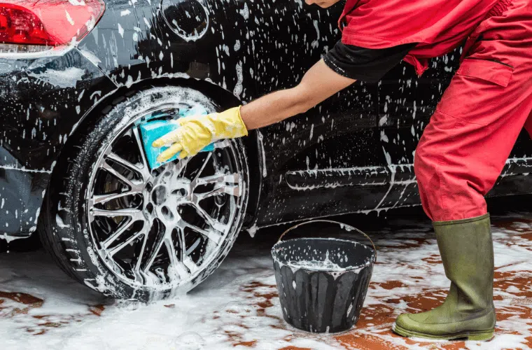 Washing a car with soapy water, illustrating potential chemical run-off