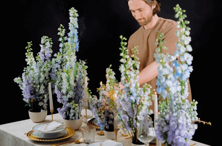 A man arranging a table floral display