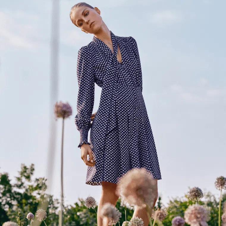 A woman wearing a blue and white polka dot dress by me+em