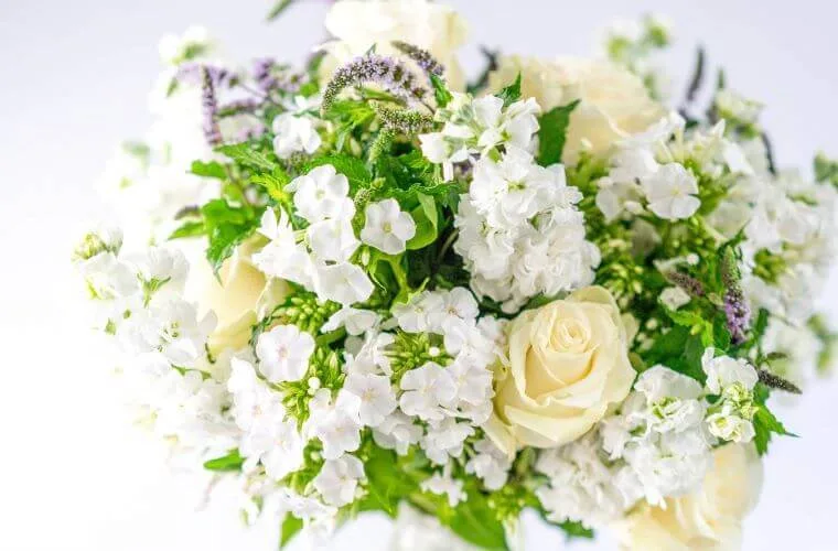 White roses with stock and mint bouquet by blooming haus