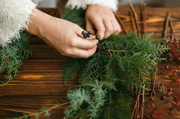 A woman's hands sorting foliage for a wreath