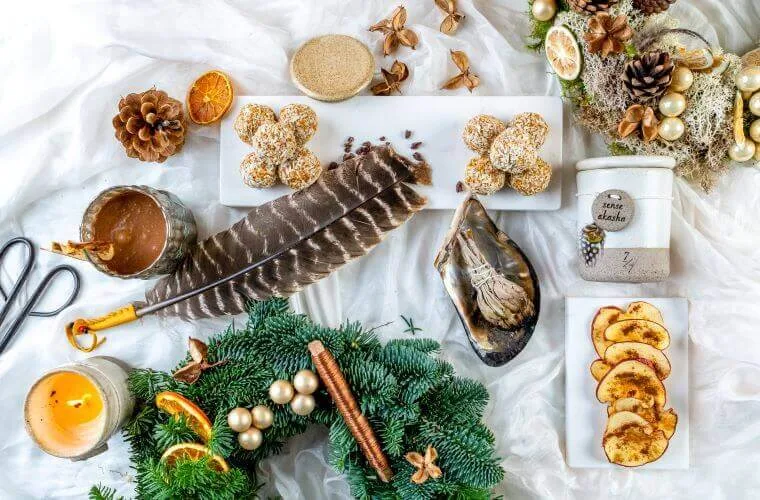 Materials for a wreath including feathers, pine cones, and dried fruit
