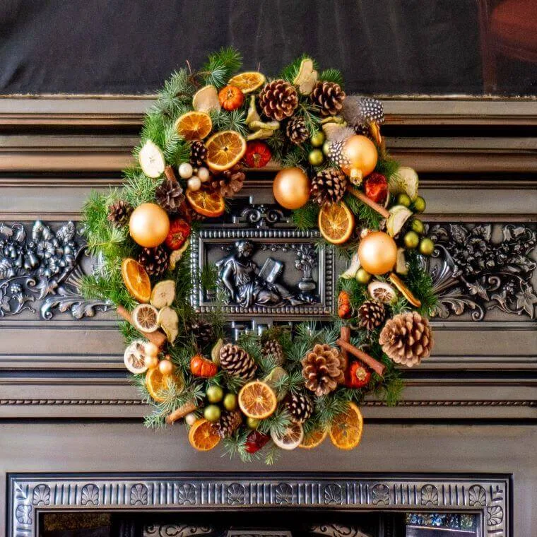 A winter wreath with slices of orange, pine cones, and baubles