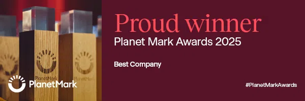 Three wooden-and-glass Planet Mark awards sit on the left. On the right, bold red text reads: "Proud winner Planet Mark Awards 2025, Best Company." The Planet Mark logo and hashtag #PlanetMarkAwards appear on a dark red background.